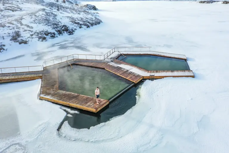 Man standing at the edge of Vok Baths during winter