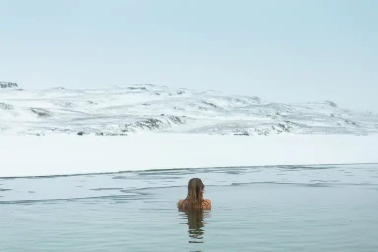 Girl watching the lake in Vok Baths pool during winter