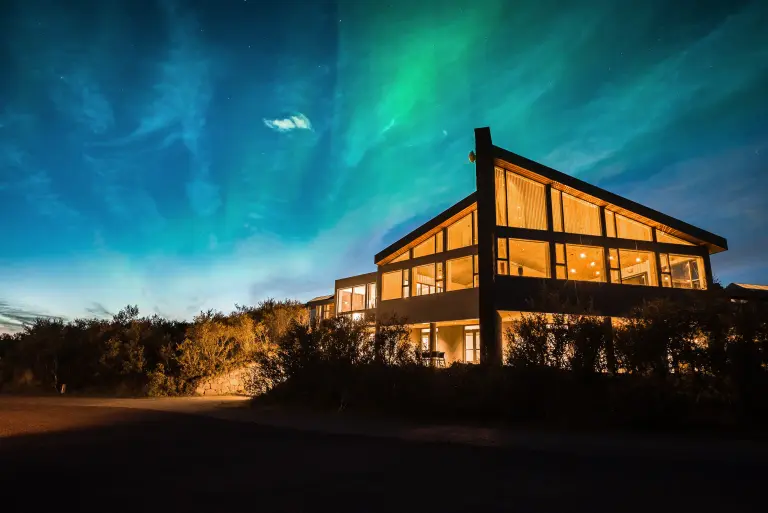 Husafell Hotel at night, with aurora borealis above