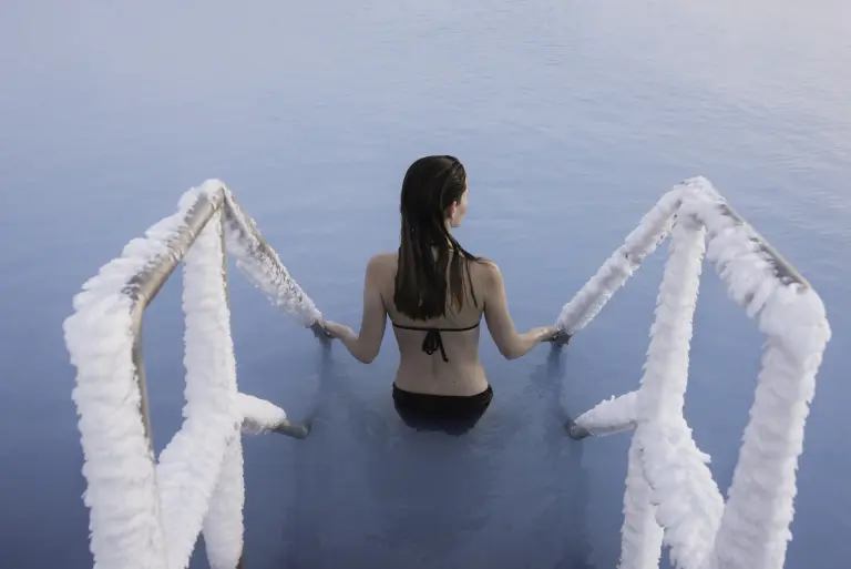 Myvatn Nature Baths in Winter - a woman is getting into the pool